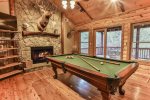Den with pool table, custom stone wood burning fireplace TV
